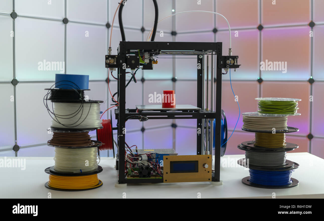 Stampante 3d e filamenti di plastica sul colore di sfondo Foto Stock