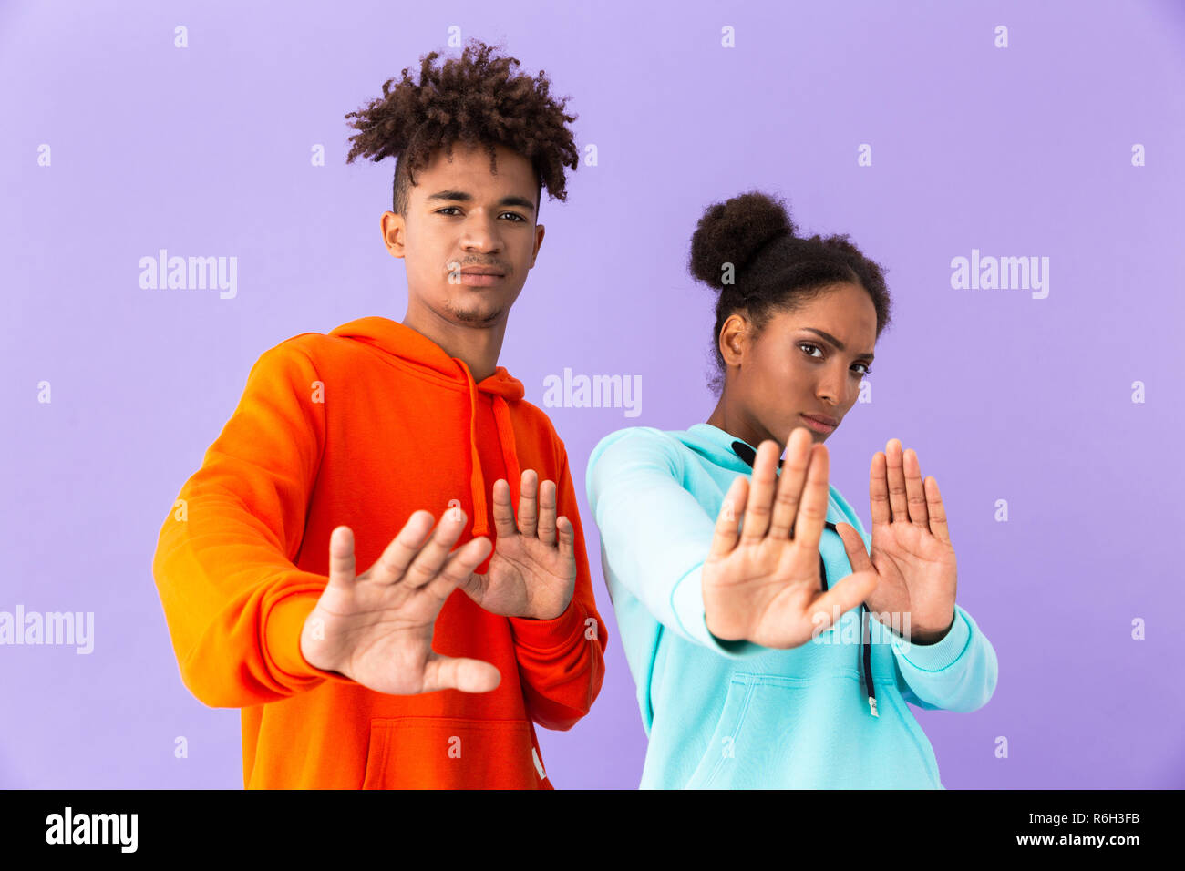 Foto di scontento americano africano giovane in abiti colorati facendo arrestare i gesti isolati su sfondo viola Foto Stock
