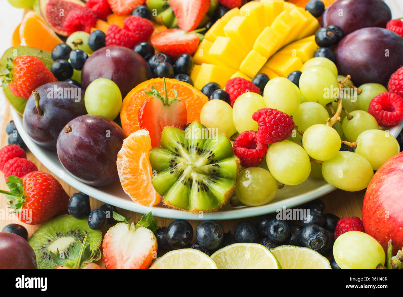 Un assortimento di frutti e bacche platter, fragole mirtilli, mango orange, Apple, uva da tavola, kiwi sfondo, il fuoco selettivo Foto Stock