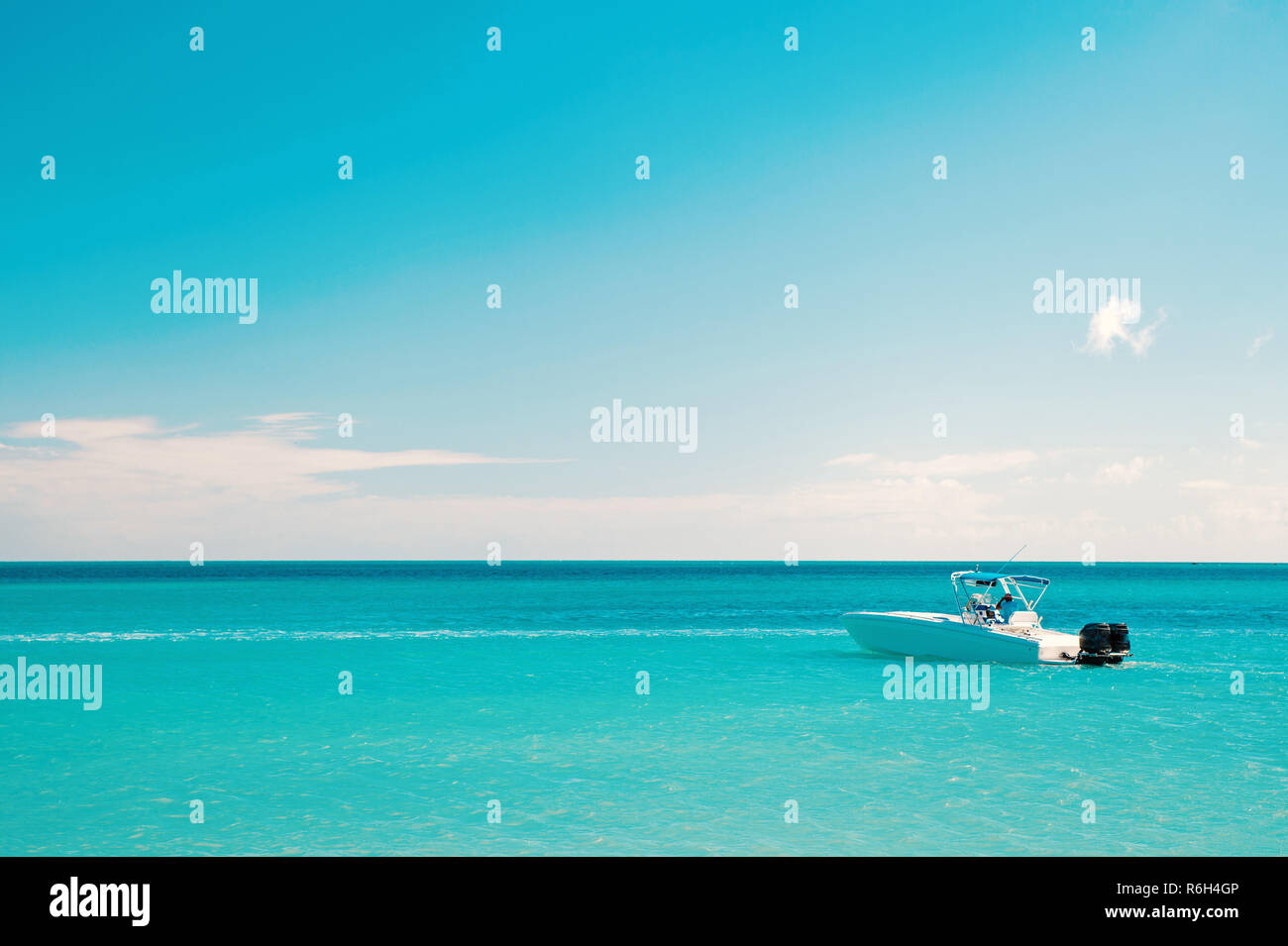 Il lusso di passare una vacanza sul mare. Esotiche della bellissima spiaggia di Marina di Antigua St. Johns con yacht barca in acqua blu e il cielo con le nuvole di piccole dimensioni Foto Stock