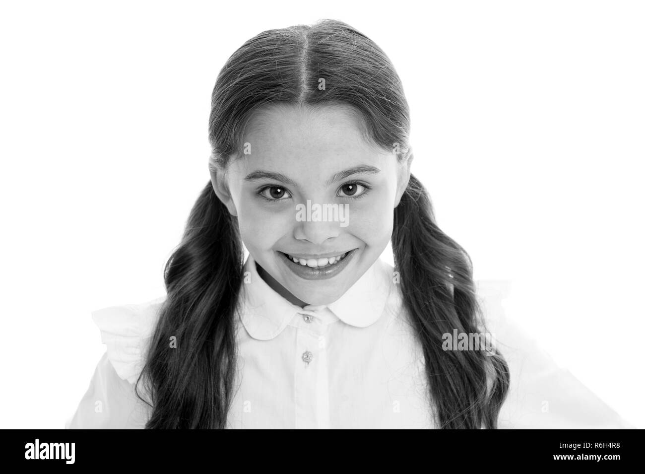 Salone di parrucchiere Servizi per bambina. Poco ragazza sorridente con i capelli lunghi isolati su bianco. Bambino felice con sorriso adorabile. Una perfetta acconciatura. Salone di bellezza. Cura della pelle e dei capelli. Foto Stock