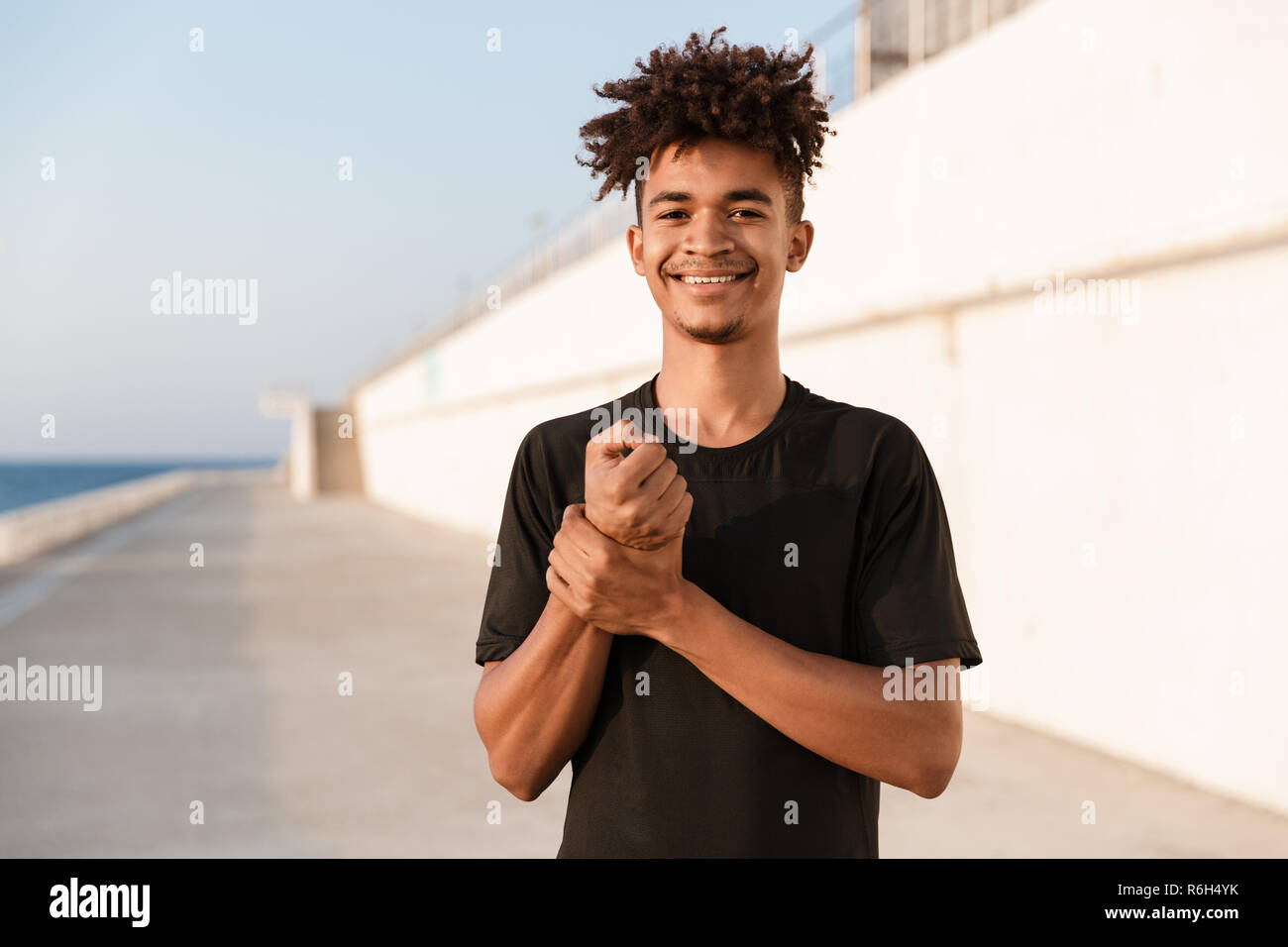 Immagine del bel giovane ragazzo sportivo in posa all'aperto sulla spiaggia. Foto Stock