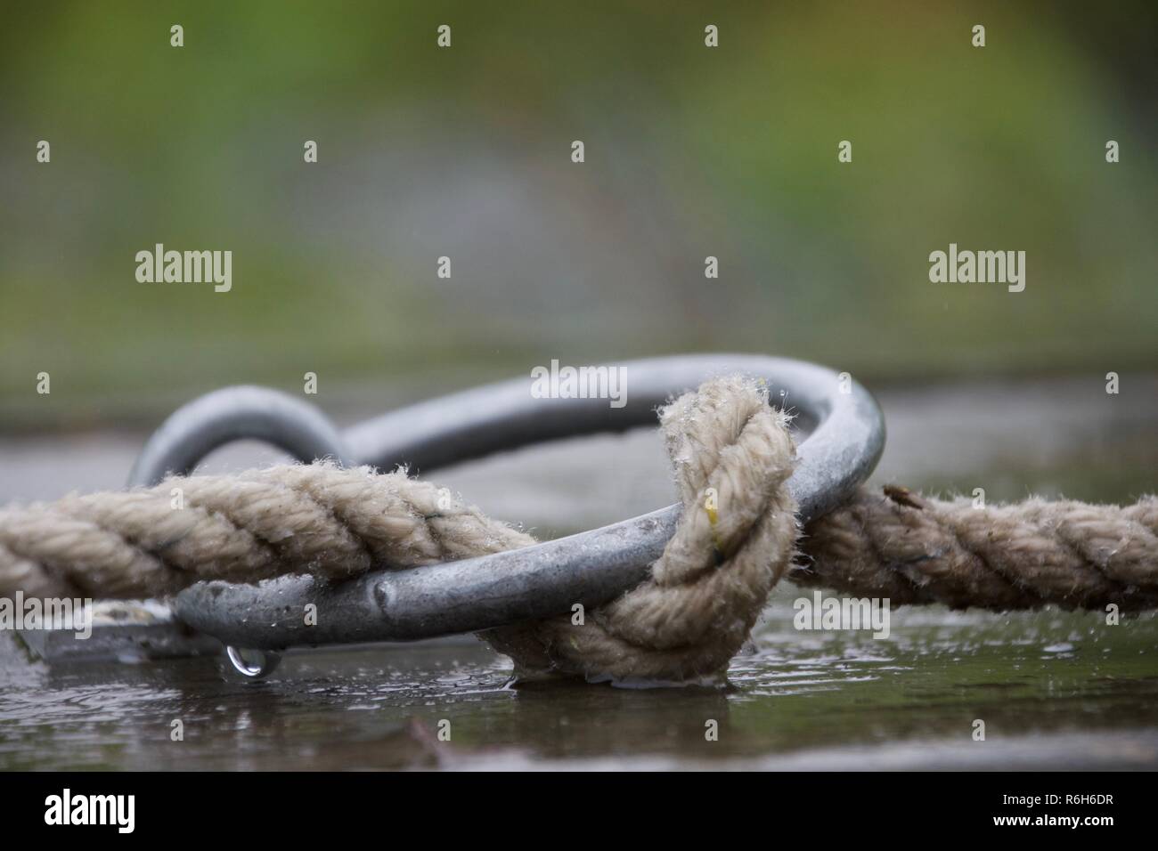 Un panno di corda attorcigliata attraverso un anello metallico Foto Stock