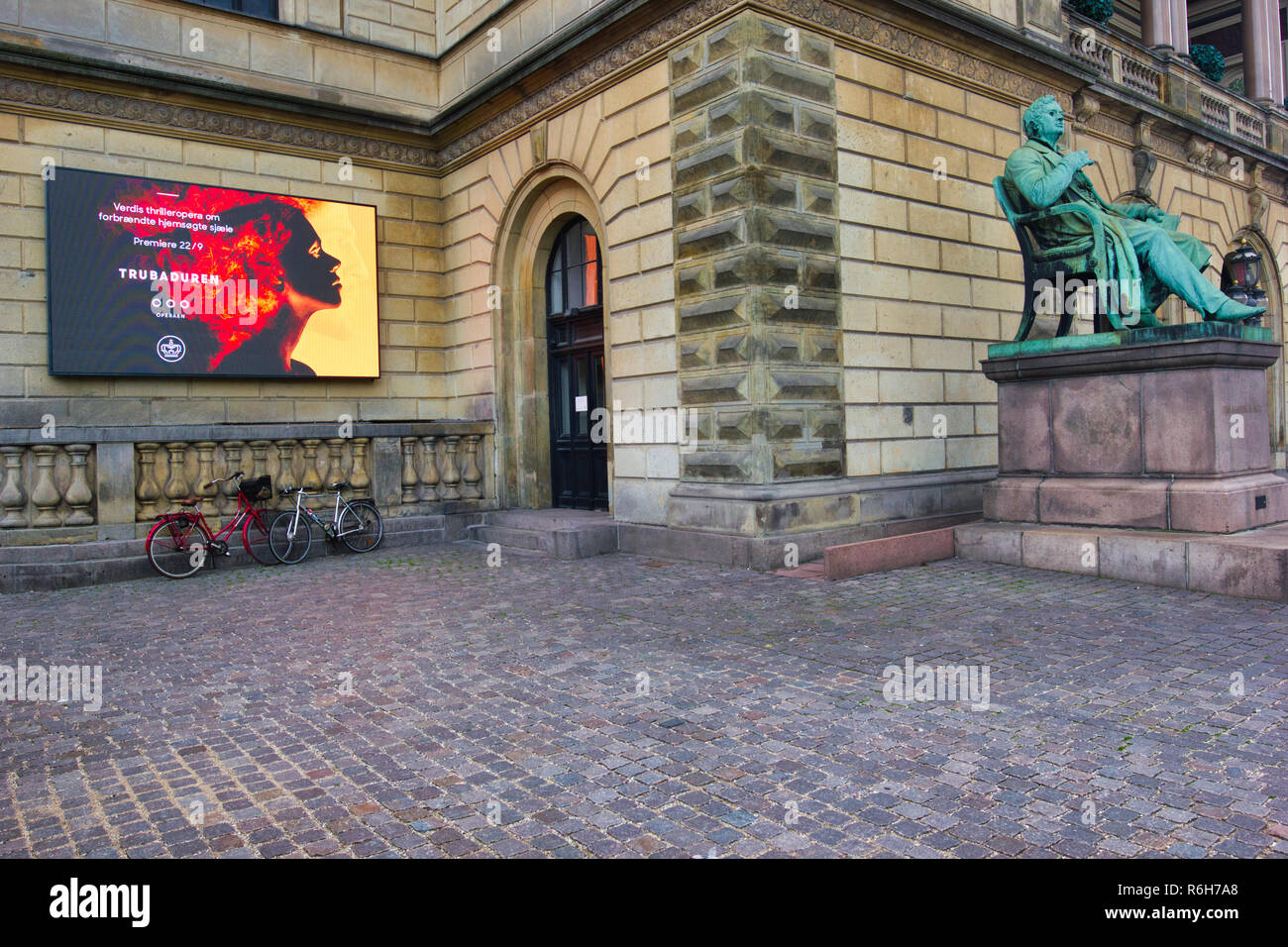 Seduto statua di Adam Oehlenschlager e la pubblicità elettronica display board fuori del Royal Danish Theatre (Kongelige Teater), Copenhagen, Danimarca Foto Stock