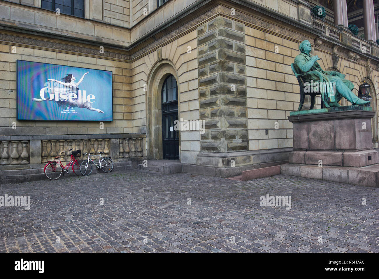 Seduto statua di Adam Oehlenschlager e la pubblicità elettronica display board fuori del Royal Danish Theatre (Kongelige Teater), Copenhagen, Danimarca Foto Stock