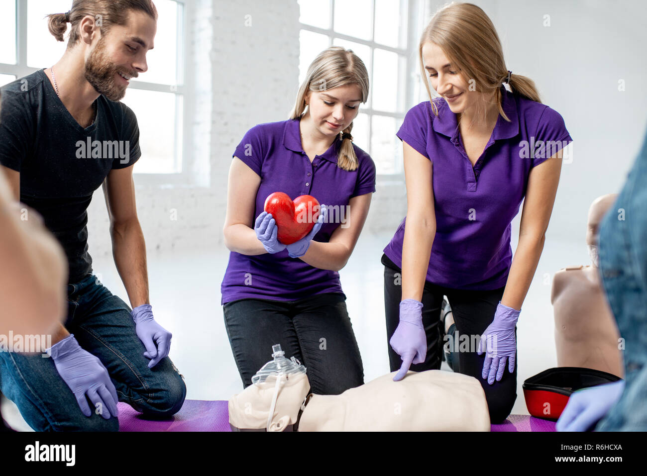 Medical istruttore azienda modello cuore durante i primi corsi di aiuto per interni Foto Stock