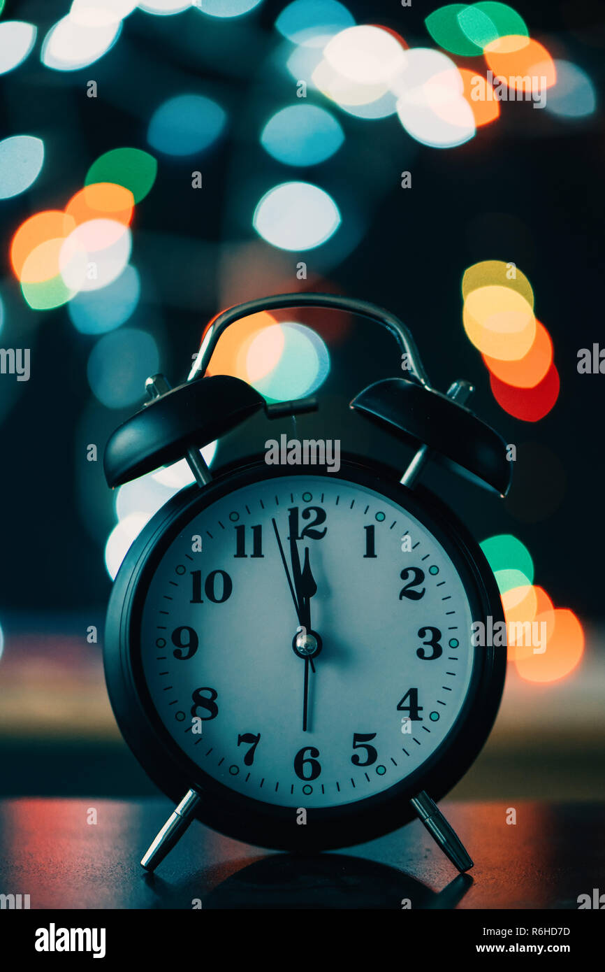 Nuovo Anno di mezzanotte retrò orologio con luci bokeh di fondo in background Foto Stock