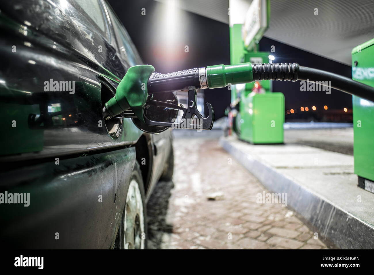 Gli ugelli di rifornimento di carburante in corrispondenza della stazione di riempimento vicino fino a notte Foto Stock