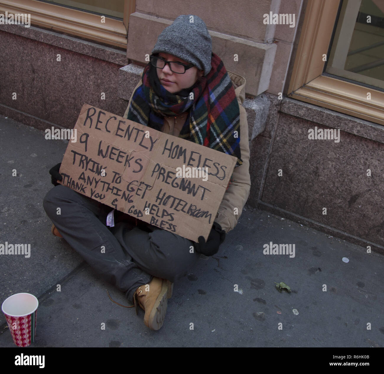 Recentemente giovani senzatetto donna incinta chiede aiuto per ottenere una camera di hotel su Venerdì nero lungo Broadway a New York City. Foto Stock