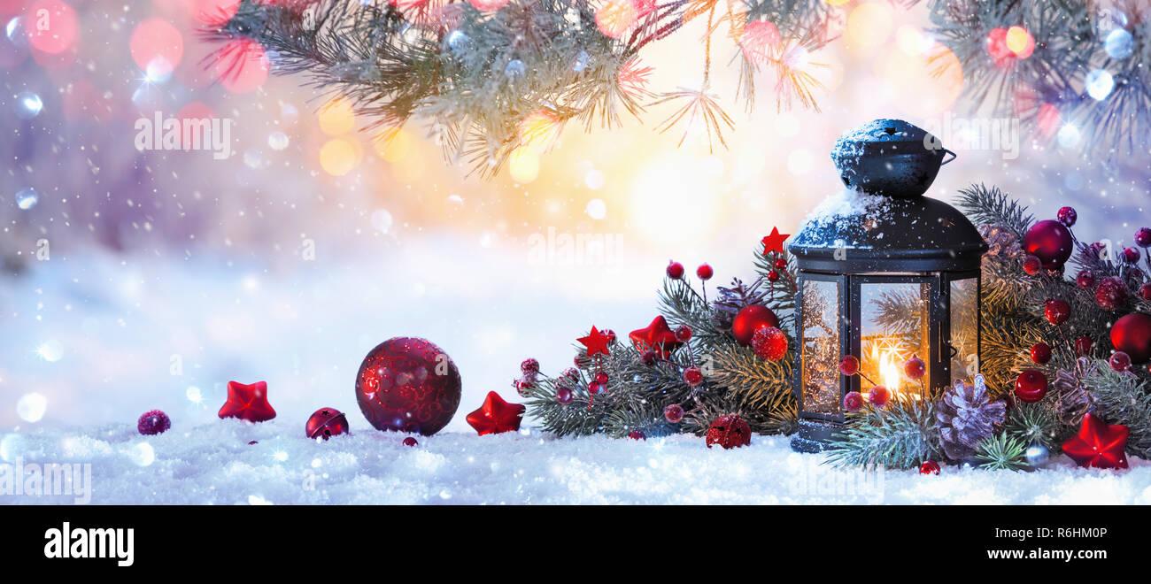 Lanterna di Natale sulla neve con ramo di abete nella luce del sole. Inverno sfondo decorazione Foto Stock