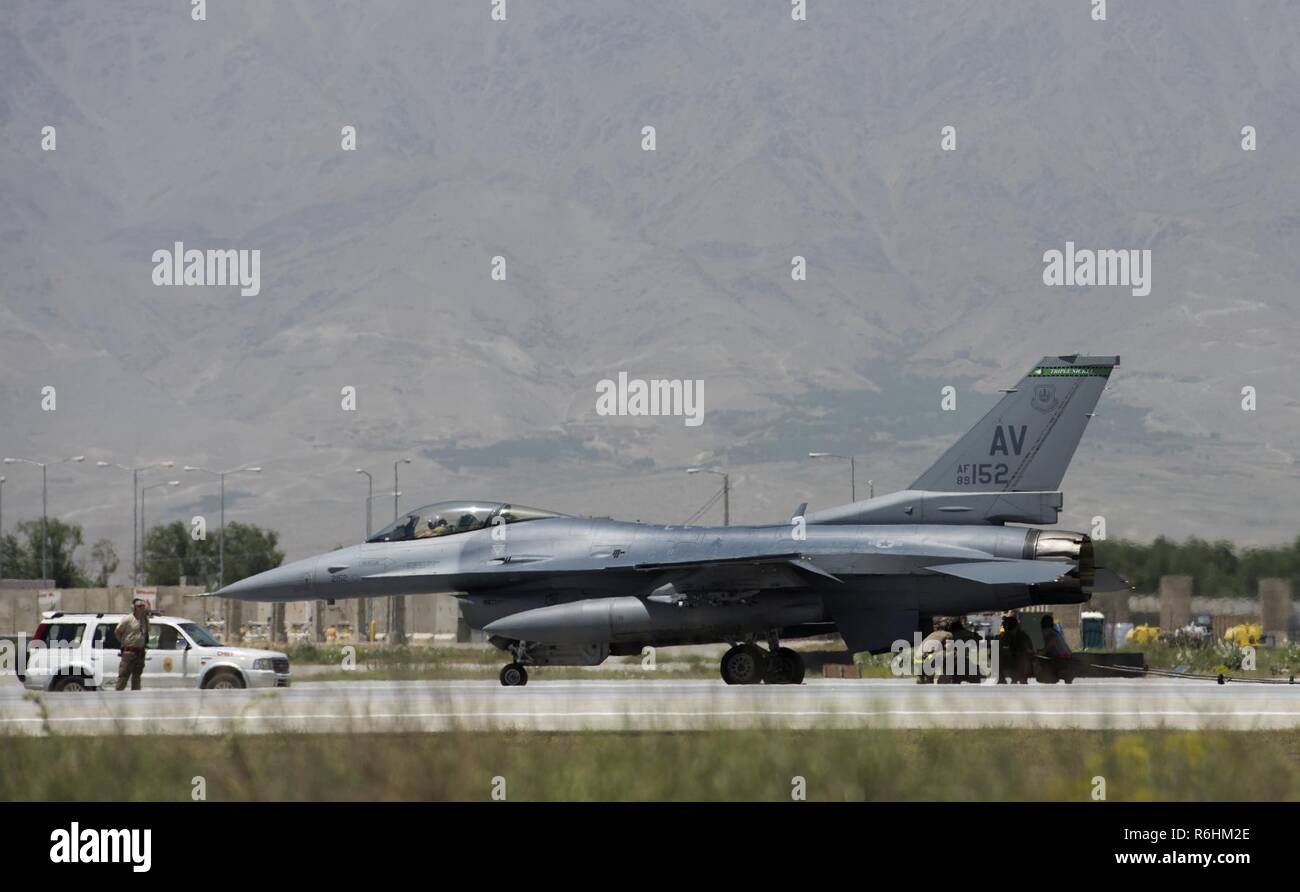 Avieri rimuovere un cavo da un F-16 Fighting Falcon, assegnato all'Expeditionary 555th Fighter Squadron, a Bagram Airfield, Afghanistan, 19 maggio 2017. Il cavo è parte del velivolo mobile sistema di arresto, il quale è usato per decelerare rapidamente un aeromobile. Foto Stock