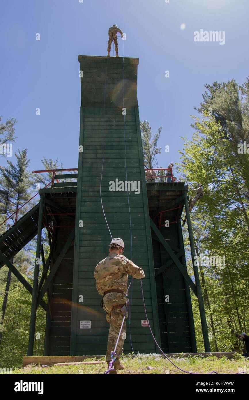 Il personale Sgt. Tyler Beck belays un soldato da reclutare Supporto Programma (RSP) giù un piede 55 a parete Bog Brook Area Formazione in Gàlaad, Maine. I soldati del RSP sono nuovi per la Guardia Nazionale e alla formazione al fine di diventare più pronto a partecipare a base di addestramento al combattimento o avanzati di formazione individuali il 20 maggio 2017. Foto Stock