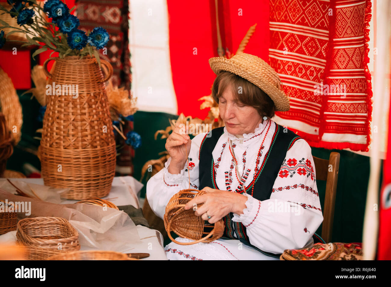 Distretti di Vetka, Bielorussia - Giugno 23, 2018: Donna nella tradizionale etnica Folk Nazionale Russa la tessitura in Costume di cestello. Cestello tessitura, basketry o cestello rendendo I Foto Stock