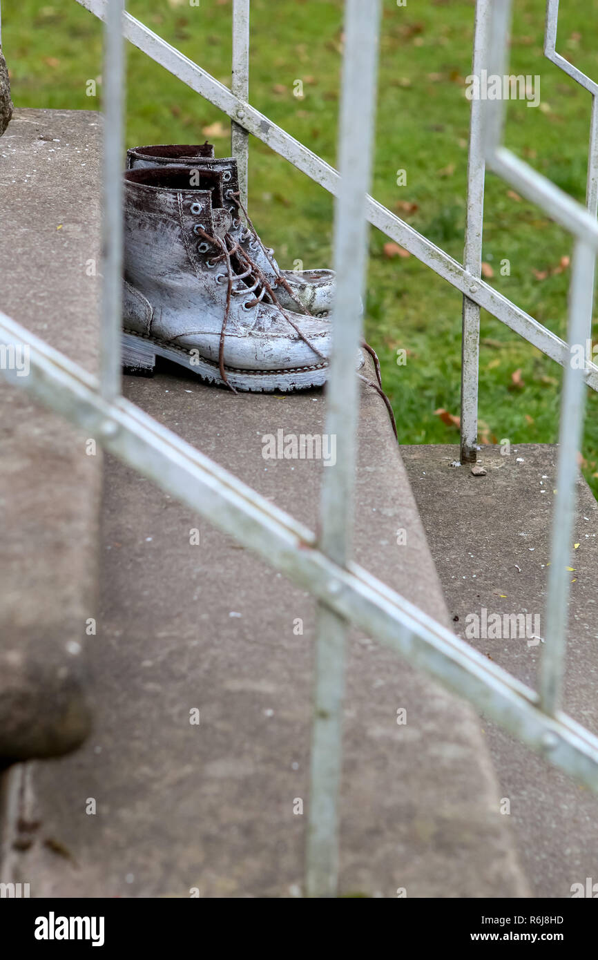 Vecchio brown stivali da lavoro. Stivali cosparse con vernice bianca. Stivali di sporco sulle scale. Dirty old workboots sulle scale. Foto Stock