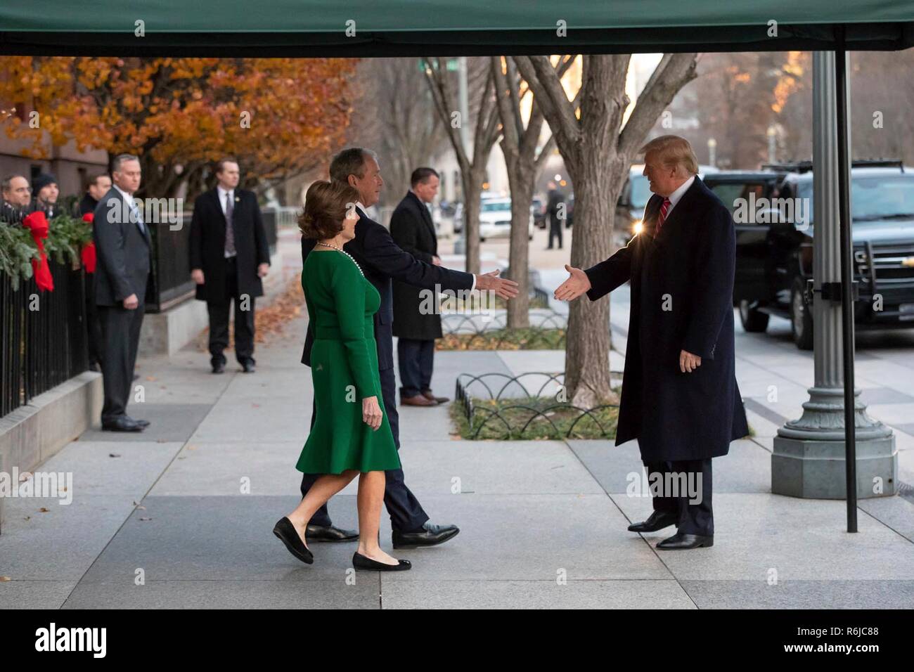 Washington DC, Stati Uniti d'America. 4 dicembre, 2018. U.S presidente Donald Trump raggiunge a salutare l ex Presidente George W Bush ed ex First Lady Laura Bush al di fuori di Blair House Dicembre 4, 2018 a Washington, DC. Bush è rimanere a Blair House per partecipare al memoriale di servizio per suo padre il compianto Presidente George H.W. Bush. Credito: Planetpix/Alamy Live News Foto Stock