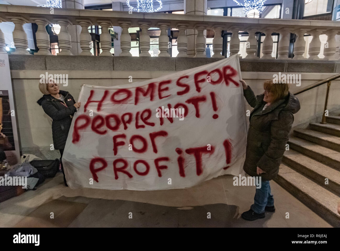 Londra, Regno Unito. Il 5 dicembre 2018. Alloggi sociali in azione gli attivisti SHAC tenere un banner "Case per persone non per profitto!' al loro annuale alternativa Premi di alloggiamento al di fuori della sede nazionale Awards dando coppe di associazioni di alloggiamento per le riparazioni di poveri, oneri per servizi sociali e pulizia dodgy sviluppo, affitti, mancanza di responsabilità & spin, blundering management, povertà pay, punitivi performance management, implacabile ristruttura e nel complesso il bullismo. Credito: Peter Marshall / Alamy Live News Foto Stock