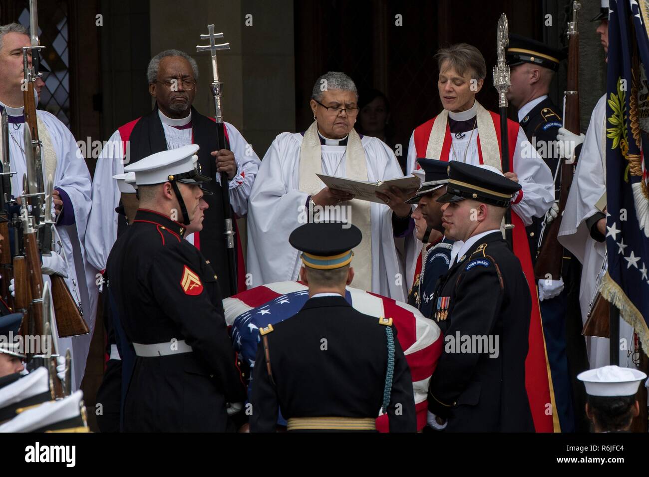 Presiede il Vescovo Michael Curry, sinistra, Rev. Canon Rosemarie Logan Duncan, centro e Vescovo Mariann Edgar Budde ricevere la bandiera-drappeggiato scrigno di ex presidente George H.W. Bush come si arriva per i funerali di Stato presso la Cattedrale Nazionale il 5 dicembre 2018 a Washington, DC. Bush, la quarantunesima edizione del presidente, morì nella sua casa di Houston all'età 94. Foto Stock