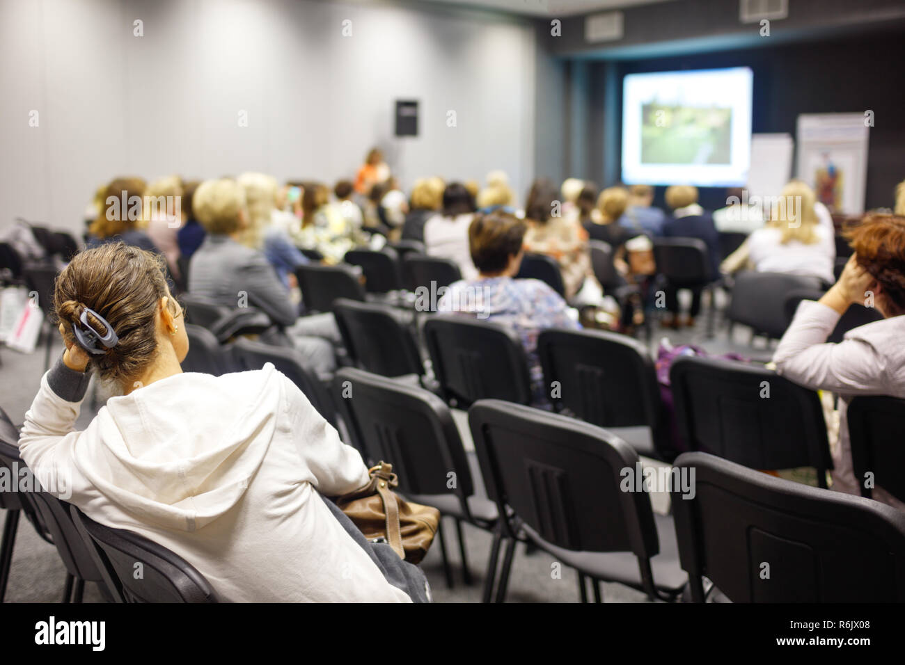 Business Woman è boredand su сonference. non interessanti informazioni, mano supporta la testa Foto Stock