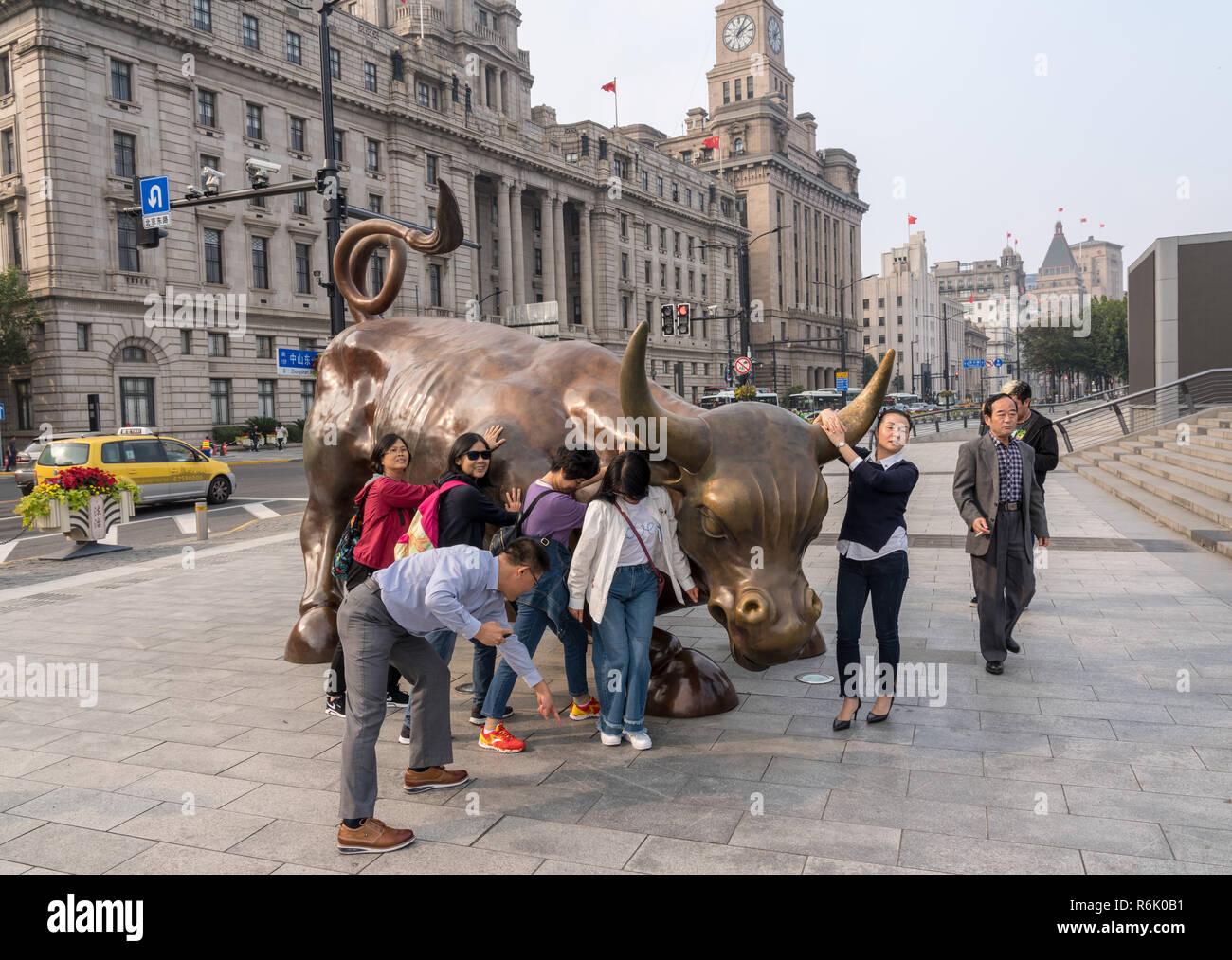 I turisti nella parte anteriore del toro infuria sul Bund Shanghai Foto Stock