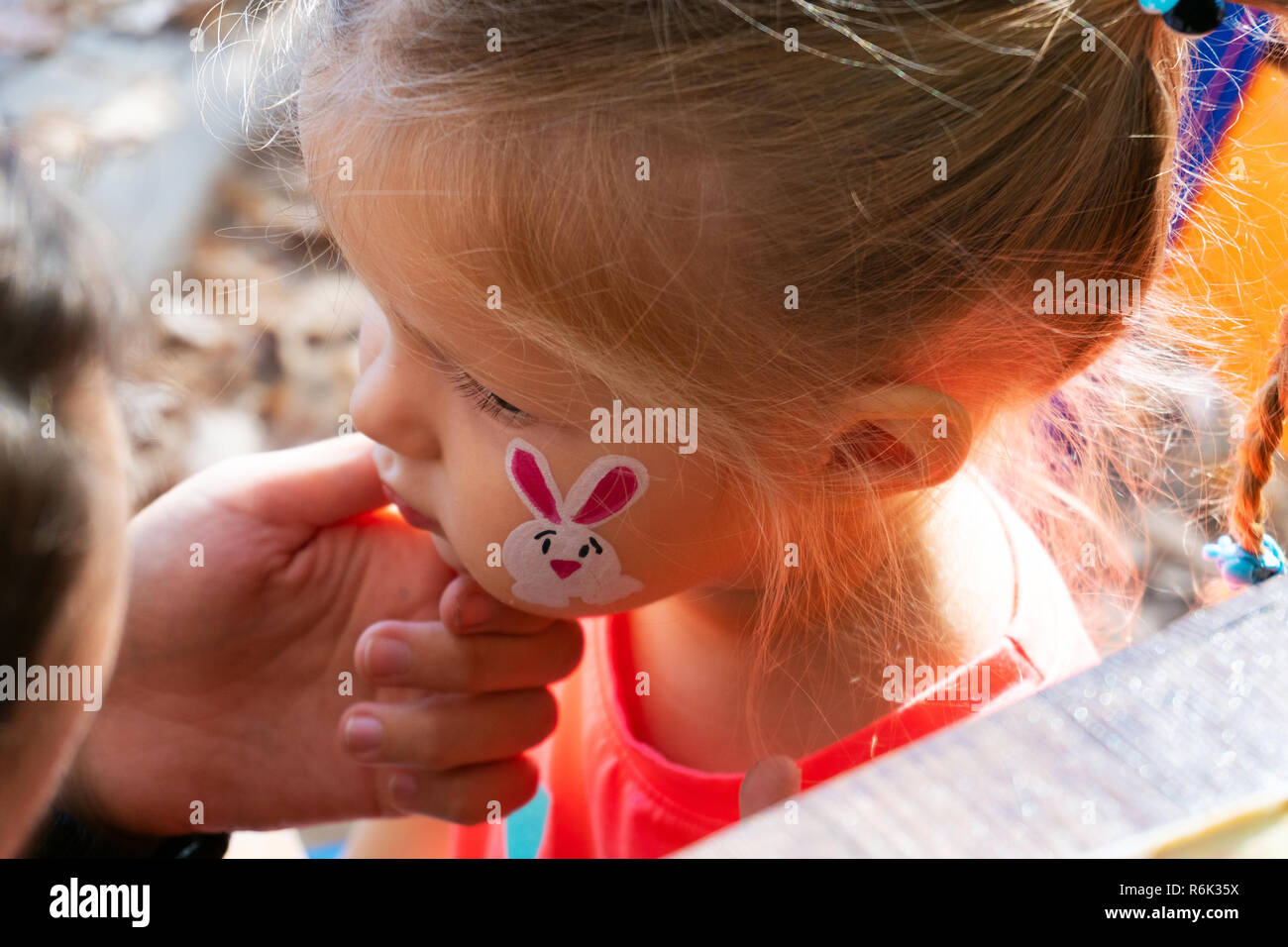 Donna dipinto sul volto della ragazza outdoor Foto Stock