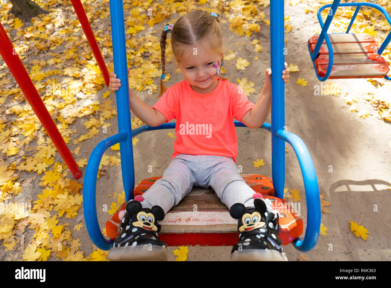 Bambina basculante in altalena nel parco Foto Stock