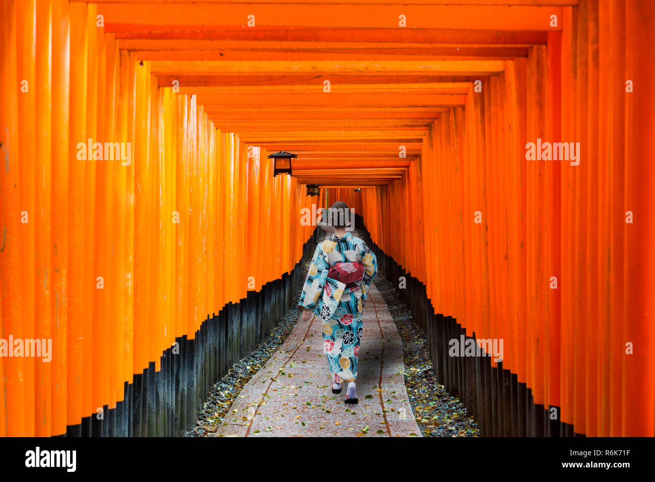 Geishe fra il rosso in legno porta dei tori a Fushimi Inari Shrine in Kyoto, Giappone. Donna indossando il tradizionale kimono giapponese di Kyoto, Giappone. Foto Stock