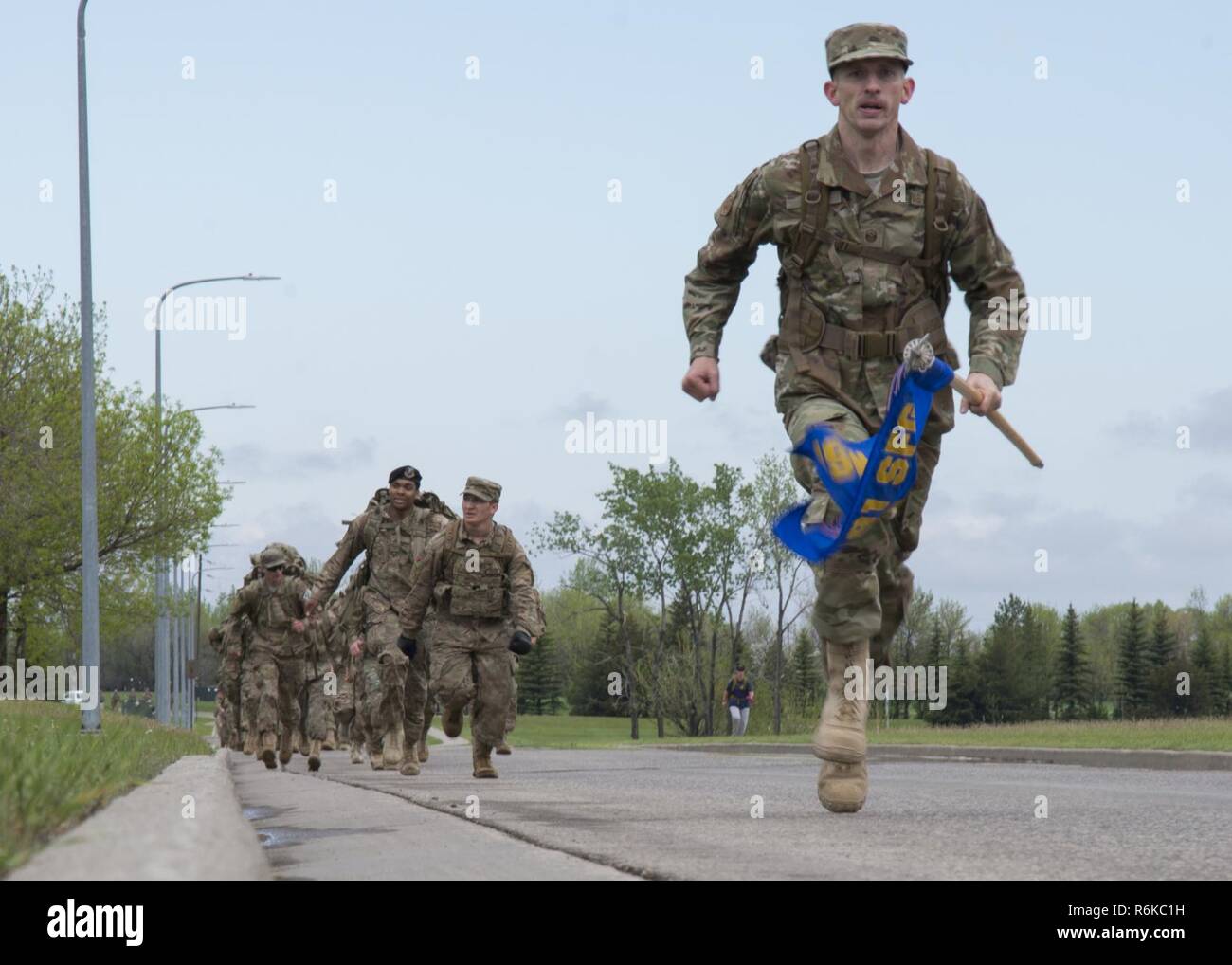 Master Sgt. Christopher Davis, 791st Missile delle forze di sicurezza squadrone primo sergente, Sprint alla fine il 5K ricordo Ruck Marzo a Minot Air Force Base, N.D., 16 maggio 2017. I membri che hanno terminato prima ruotato intorno a motivare il gruppo a fine forti insieme. Foto Stock