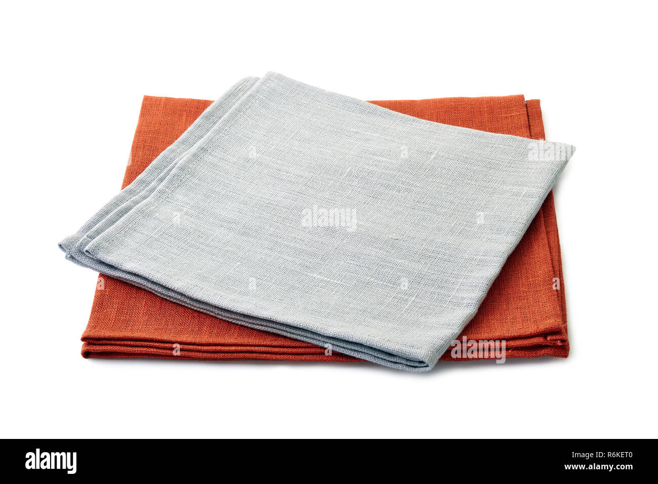 Ripiegate grigio e marrone tovaglioli tessili impilati su sfondo bianco Foto Stock