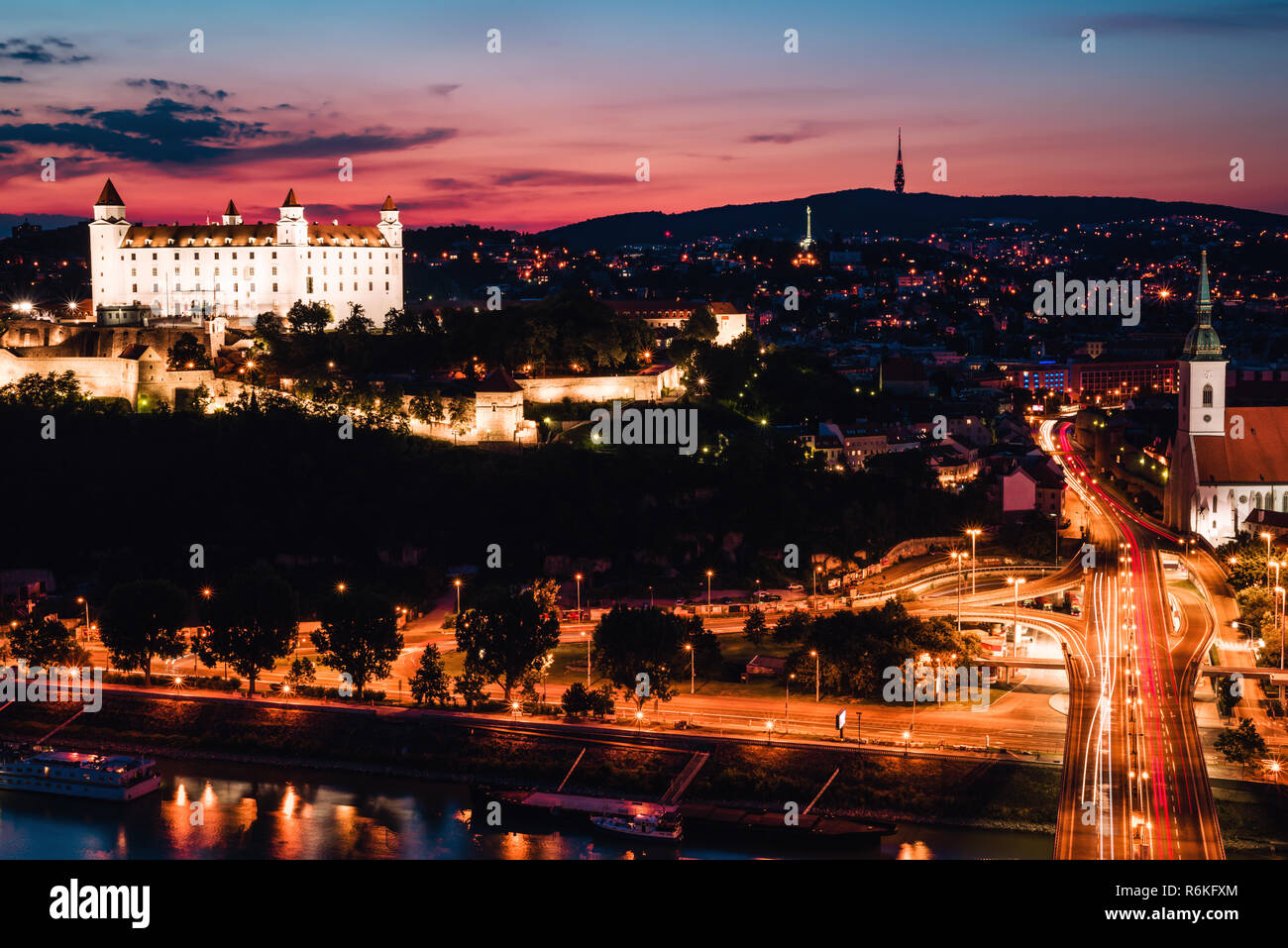 Serata panorama della città di Bratislava appena dopo il tramonto con un bellissimo cielo rosa e illuminazione notturna. Una lunga esposizione foto. Foto Stock