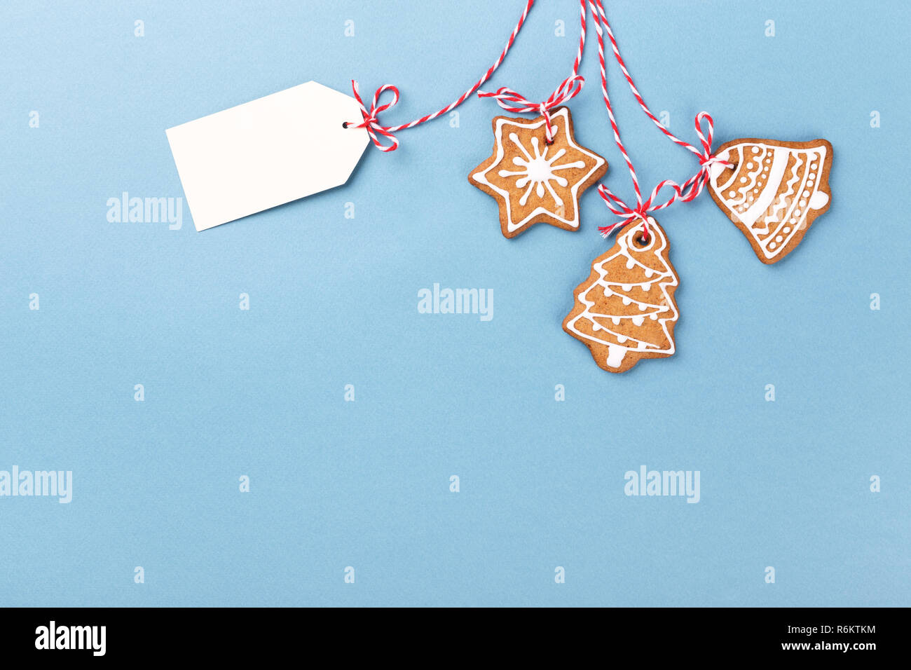 Natale gingerbread cookie con etichetta di carta appeso su sfondo blu. In stile minimale sfondo con copia spazio. Foto Stock