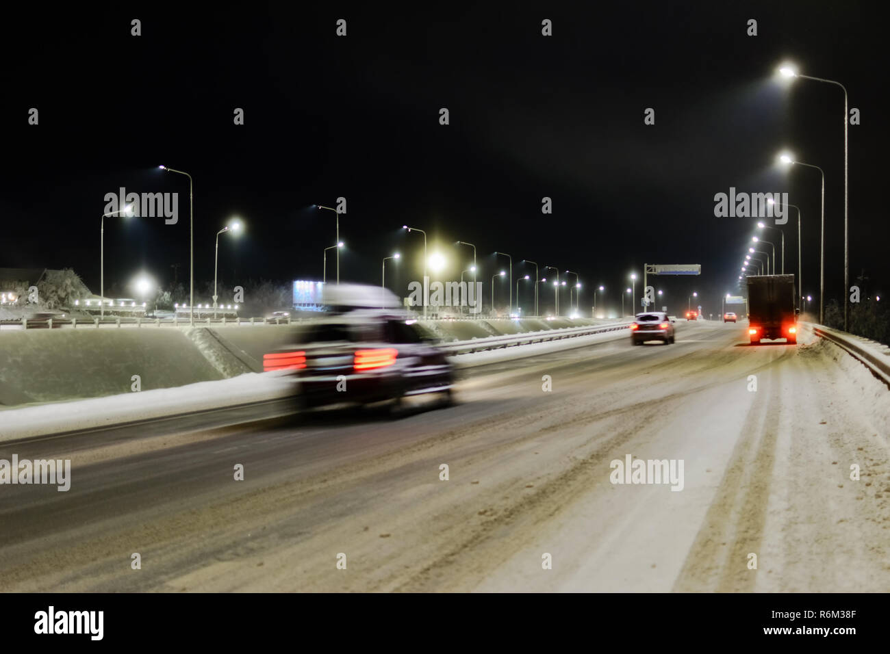 Vista la neve invernale-strada coperta con fuochi dal fragore di automobili Foto Stock