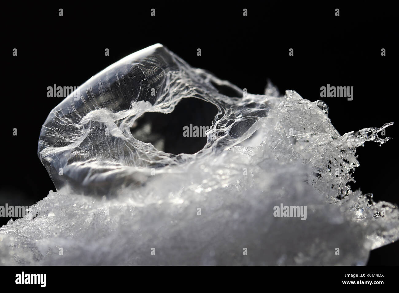 Una rotta congelati bolla di sapone nella neve con un cuore foro sagomato. la rottura di una bolla di sapone sembra un uovo alieno Foto Stock
