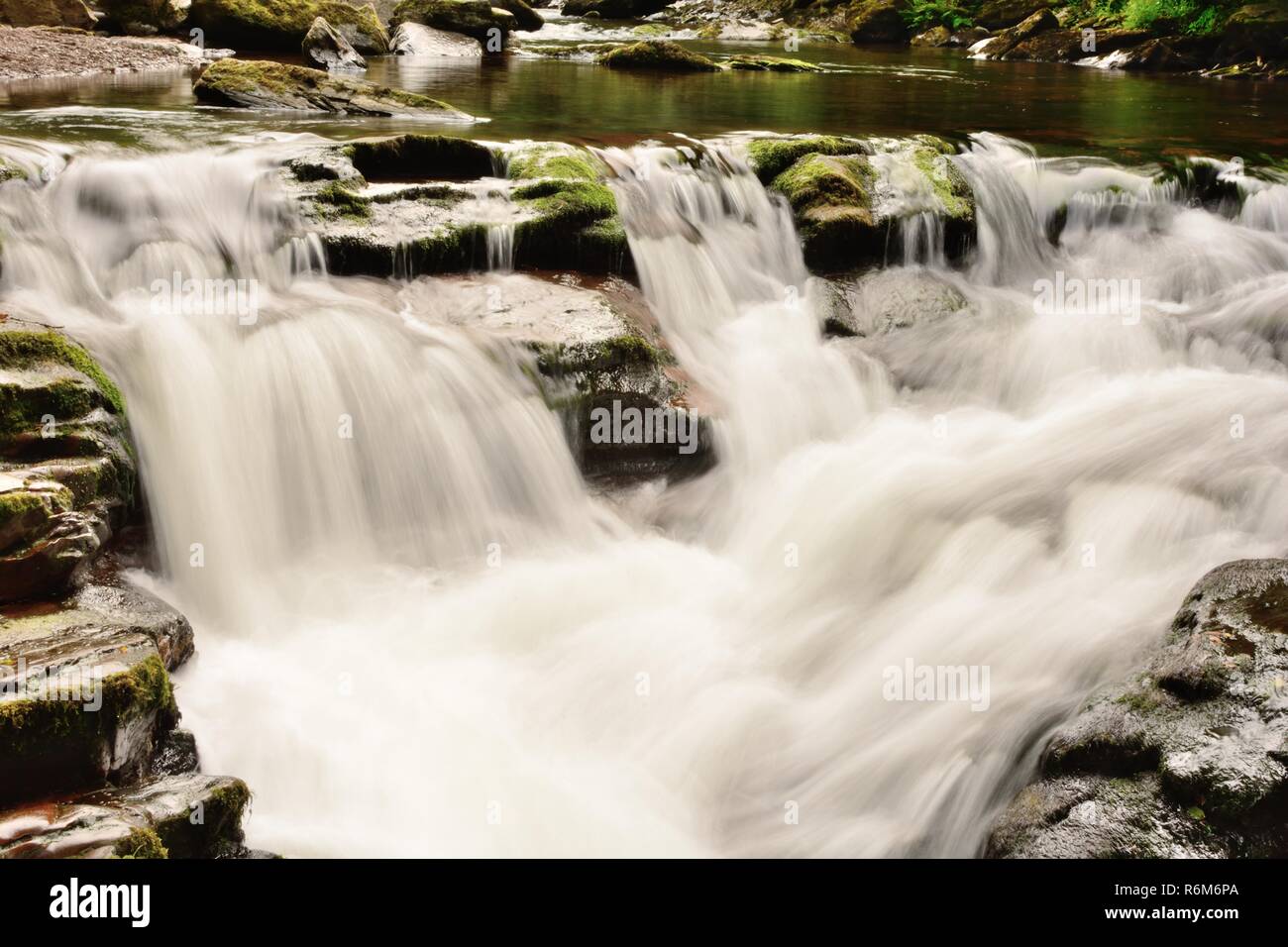 Una lunga esposizione di un waterfalll a Watersmeet in Devon Foto Stock