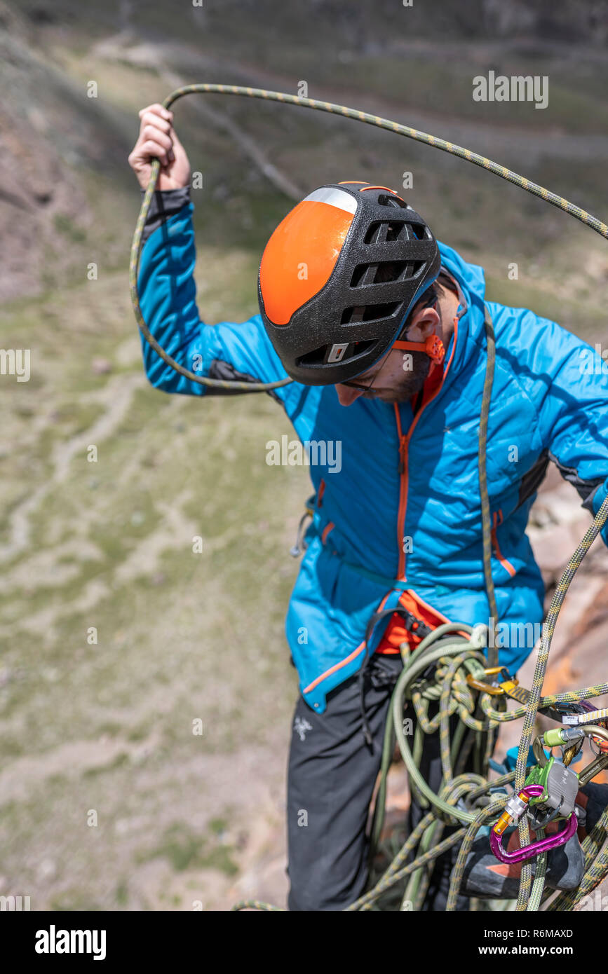 Faccia le espressioni durante un arrampicatore a salire una grande parete all'interno delle Ande, una fantastica avventura. Sorriso sul suo volti mentre andando alla cima del monte Foto Stock