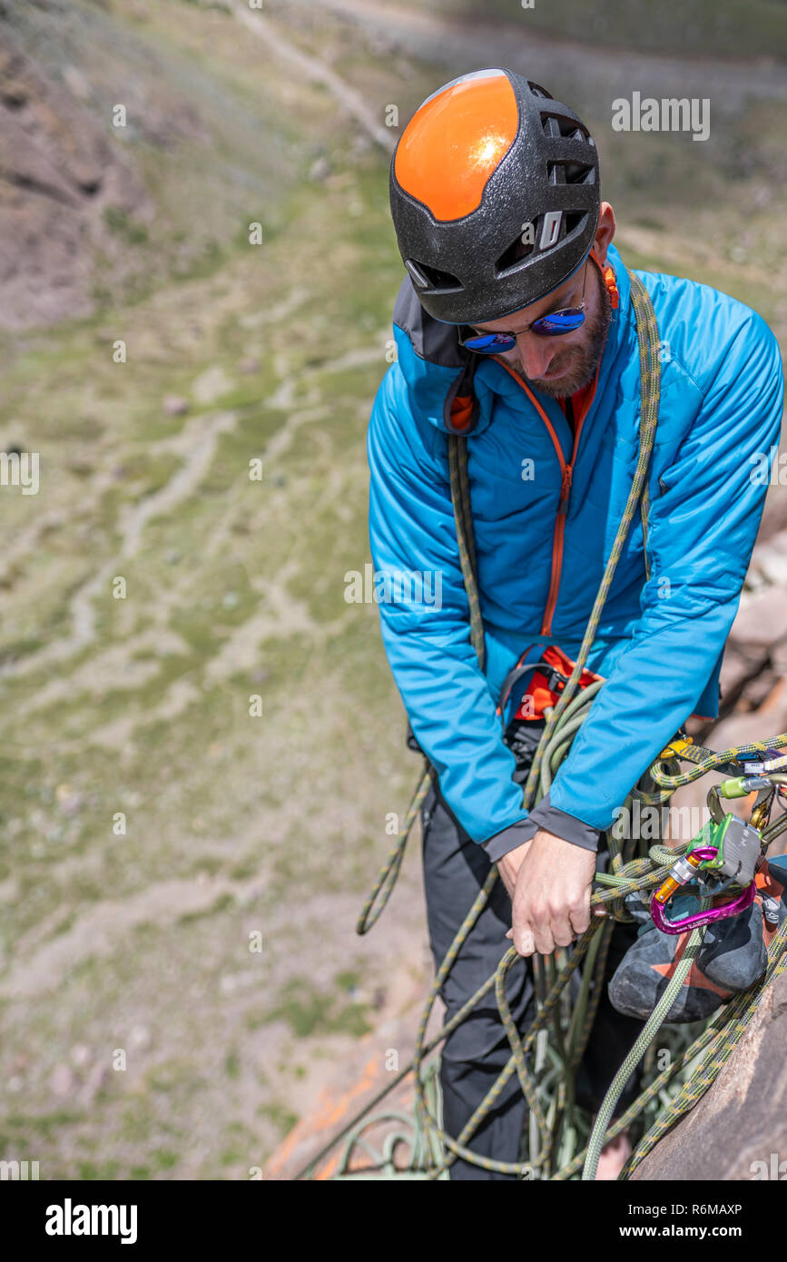 Faccia le espressioni durante un arrampicatore a salire una grande parete all'interno delle Ande, una fantastica avventura. Sorriso sul suo volti mentre andando alla cima del monte Foto Stock