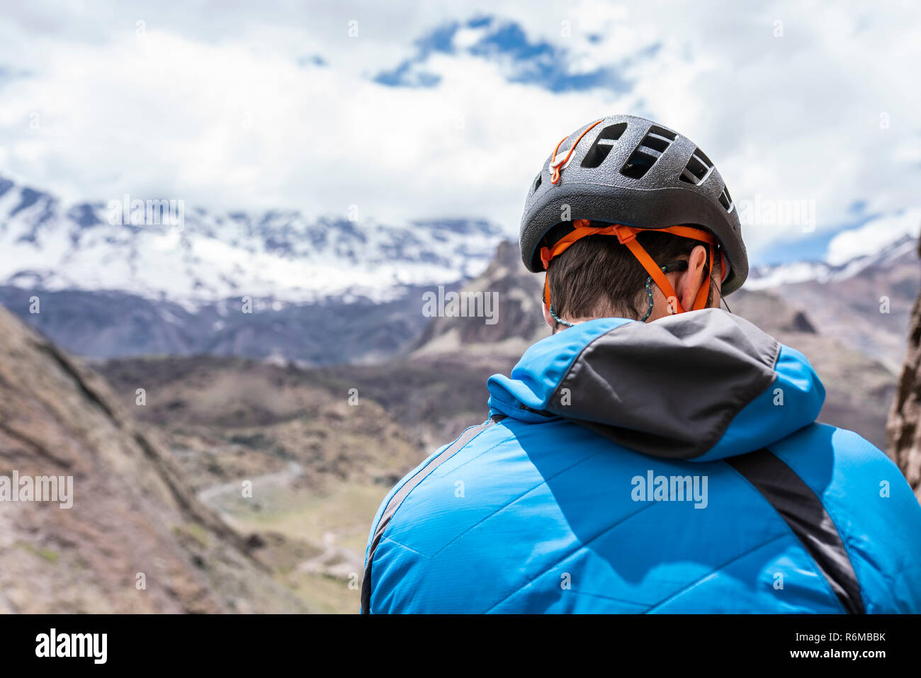 Scalatore ritratto durante una ripida parete arrampicata su roccia all'interno di montagne delle Ande su un timore reverenziale paesaggi durante un giorno nuvoloso Foto Stock