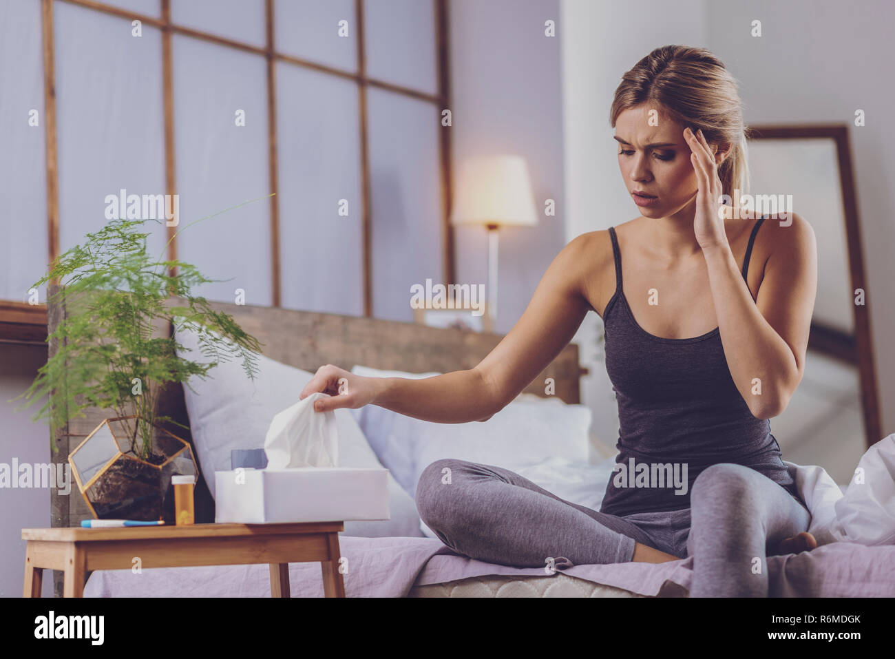 Allegro giovane donna tergi il suo naso in esecuzione Foto Stock