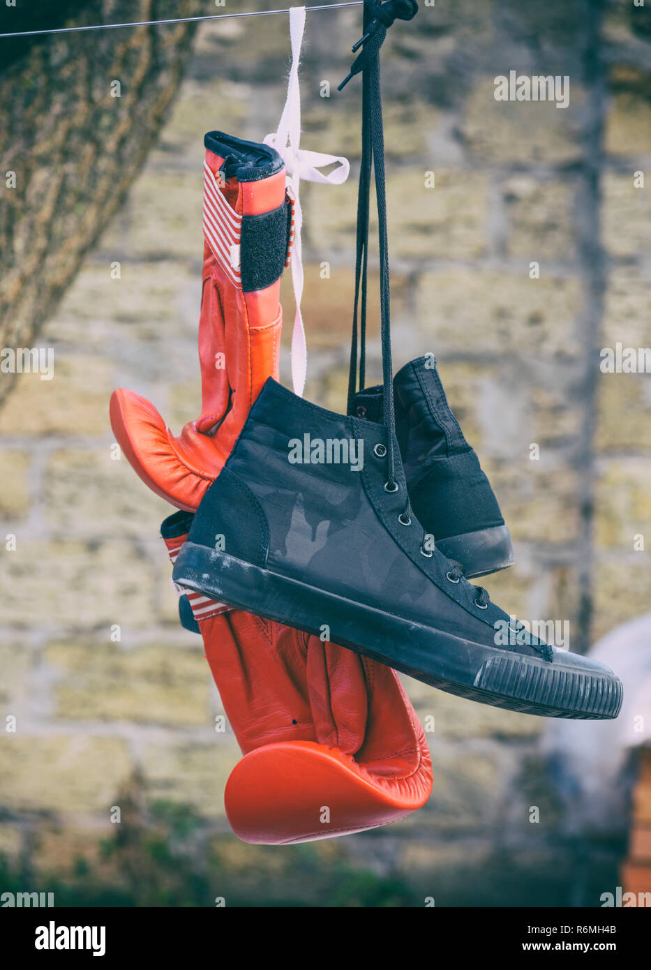 Red guantoni da pugilato e una coppia di tessuto nero sneakers Foto Stock