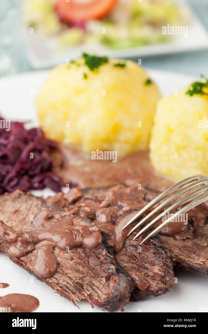 Sauerbraten con cavolo rosso su una piastra Foto Stock