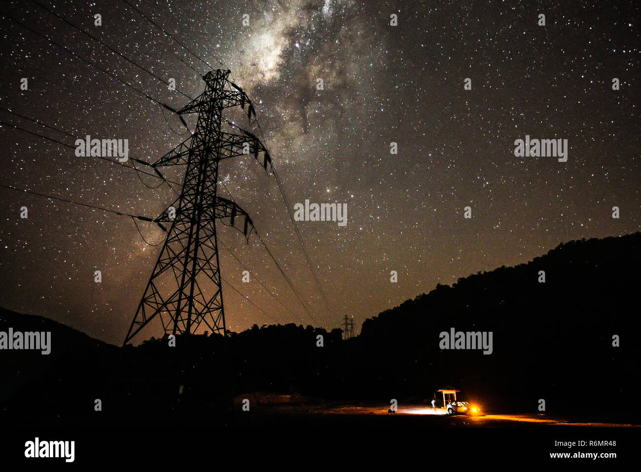 Alta tensione linea elettrica di alimentazione con la via lattea galassia in background presi in Sud Sulawesi, Indonesia Foto Stock