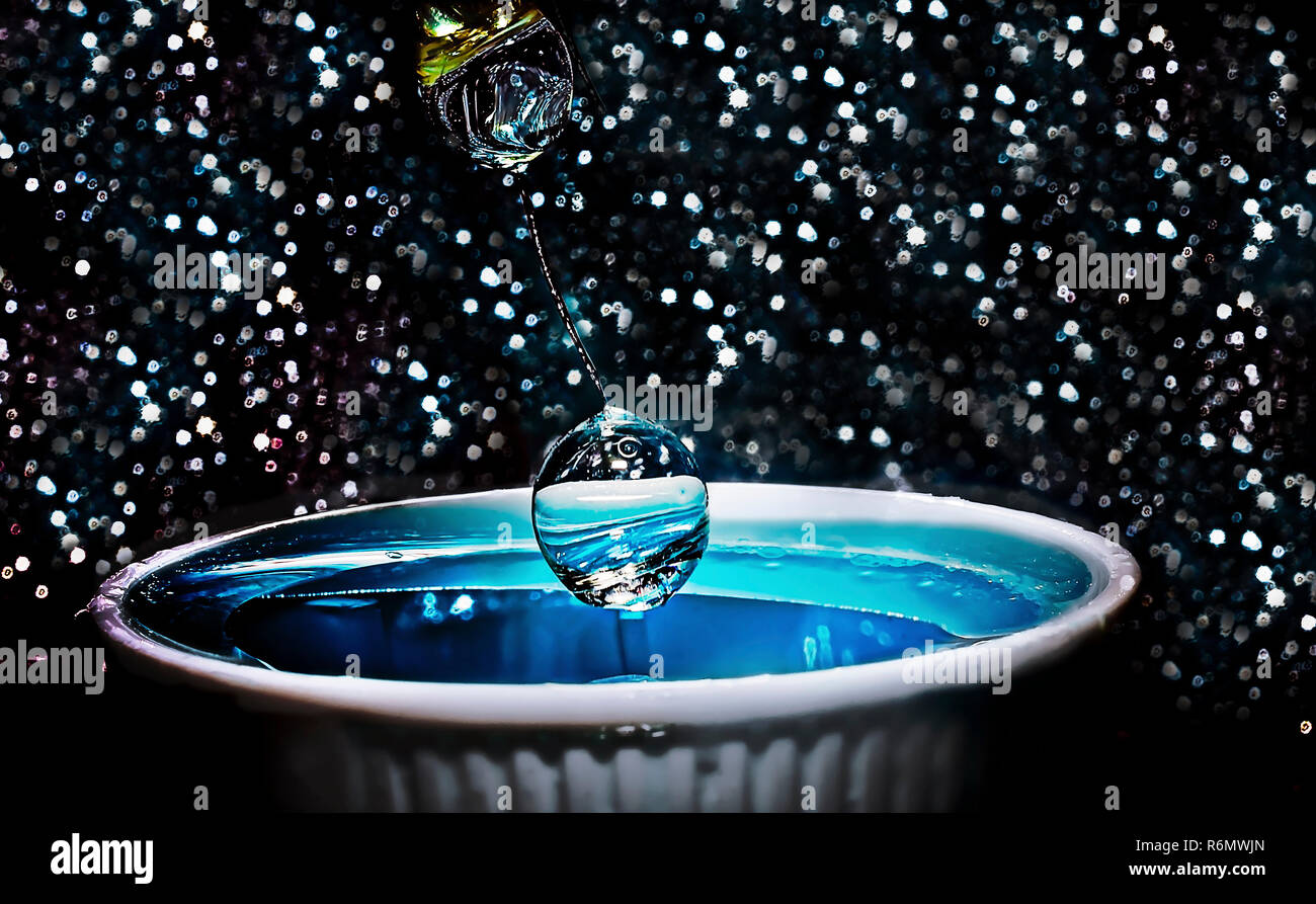 Una goccia di acqua viene arrestato con una rapida velocità di otturazione e sospesa a mezz aria prima di cadere in un piatto di portata di acqua, 21 gennaio, 2016. Foto Stock