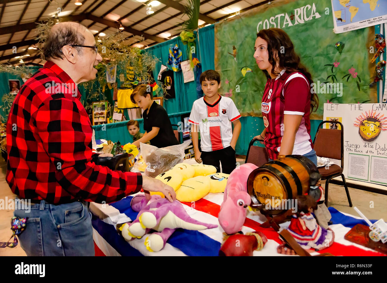 Un uomo acquista un peluche souvenir da una Costa Rican produttore presso La trentaquattresima Mobile annuale Festival Internazionale, nov. 17, 2018 in Mobile, Alabama. Th Foto Stock
