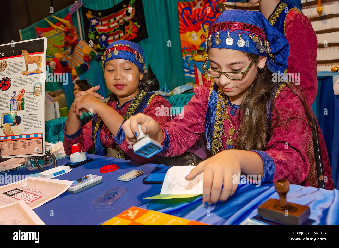 Una ragazza vestita in un tradizionale di Puerto Rican francobolli abbigliamento una simulazione di passaporto al Mobile International Festival, nov. 17, 2018 in Mobile, Alabama. Foto Stock