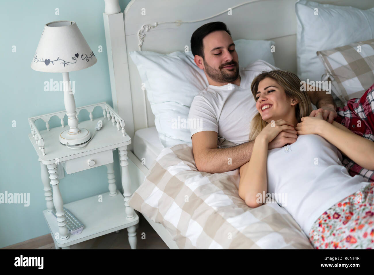 Giovane coppia attraente avente tempo di romantico nel letto Foto Stock