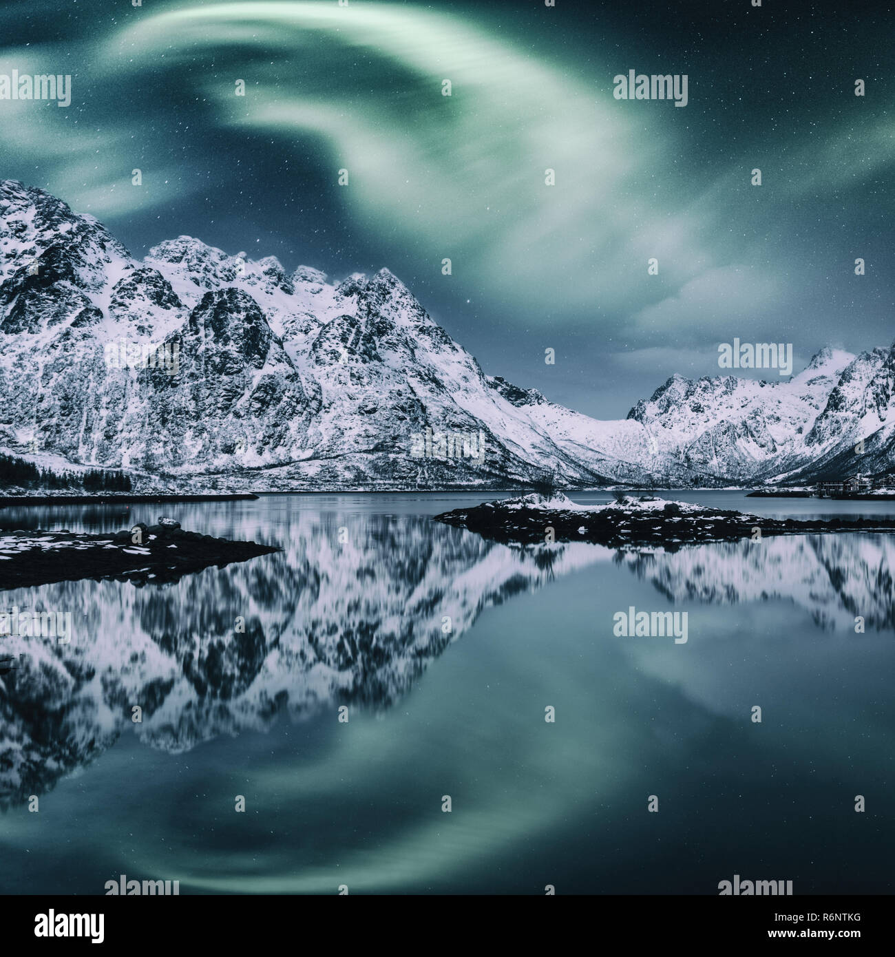 Luci del nord, Aurora Boreale in isole Lofoten in Norvegia. Notte incredibile paesaggio invernale con luci polari e cielo stellato sopra la gamma della montagna Foto Stock