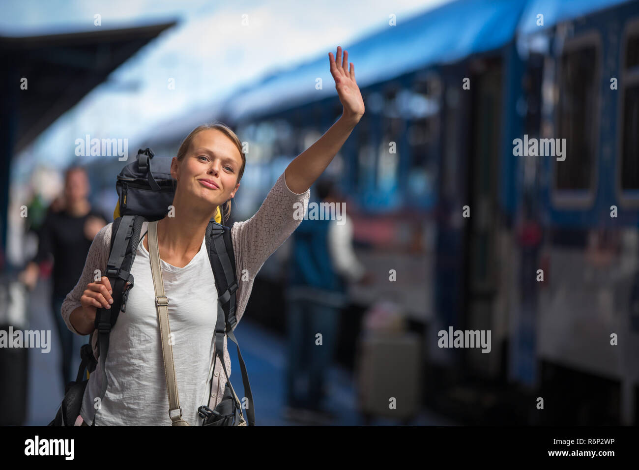 Piuttosto giovane donna di salire a bordo di un treno/essendo arrivato alla sua destinazione, in attesa che i suoi amici per scegliere il suo alto (toni di colore immagine) Foto Stock