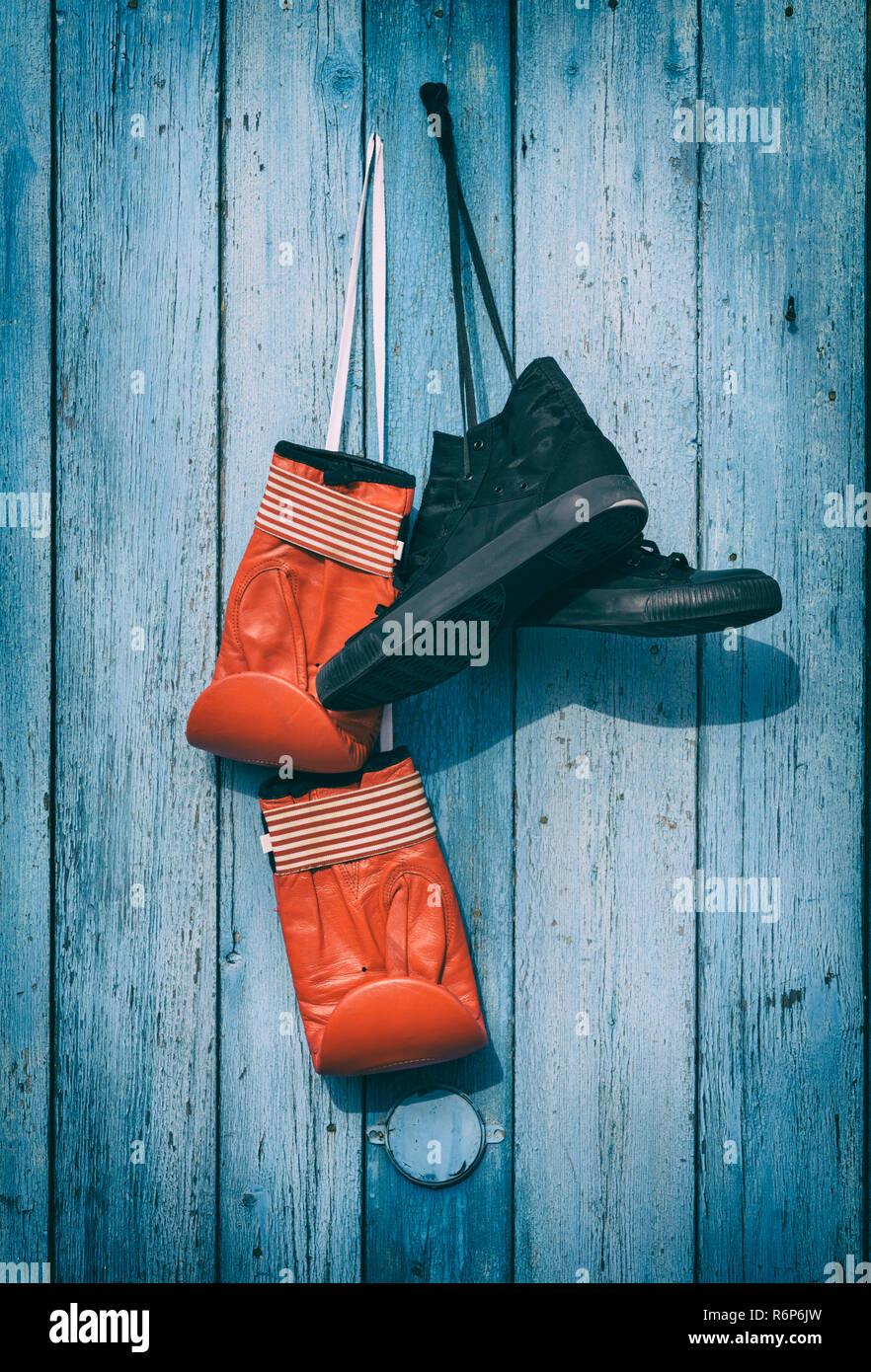 Tessuto nero indossato sneakers e Cuoio rosso guantoni da pugilato Foto Stock