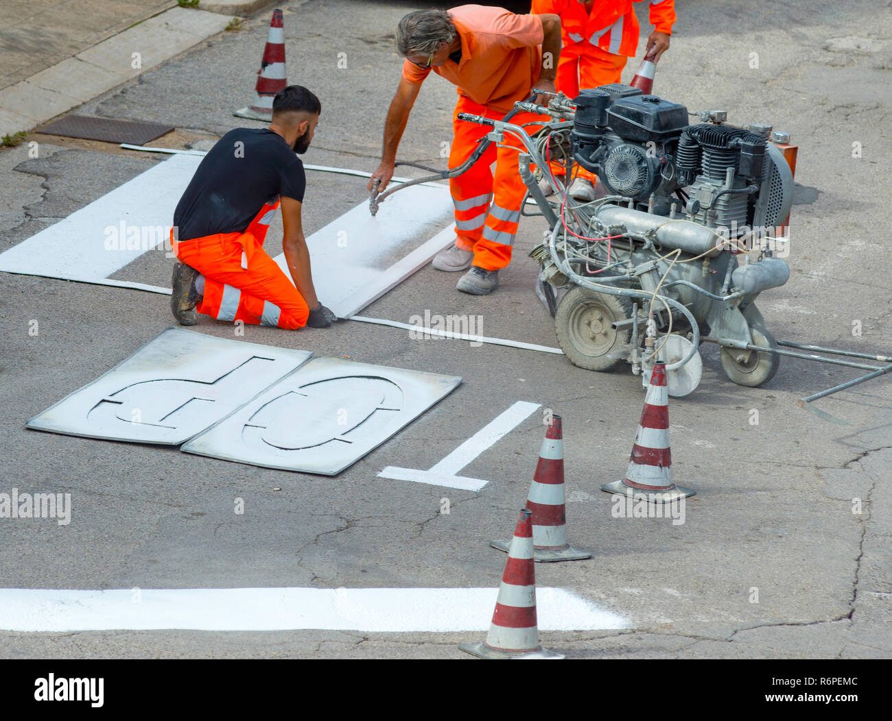Modugno, Italia - 9 Ottobre 2017: macchina e dei lavoratori di costruzione stradale per uso su strada e segno di traffico pittura Foto Stock