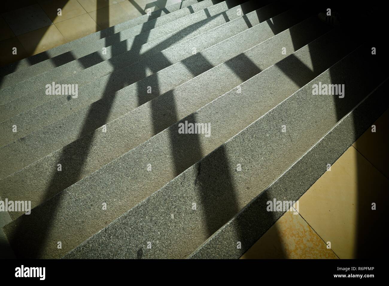 Ombra di una griglia della finestra sui gradini di una scala di una scala Foto Stock