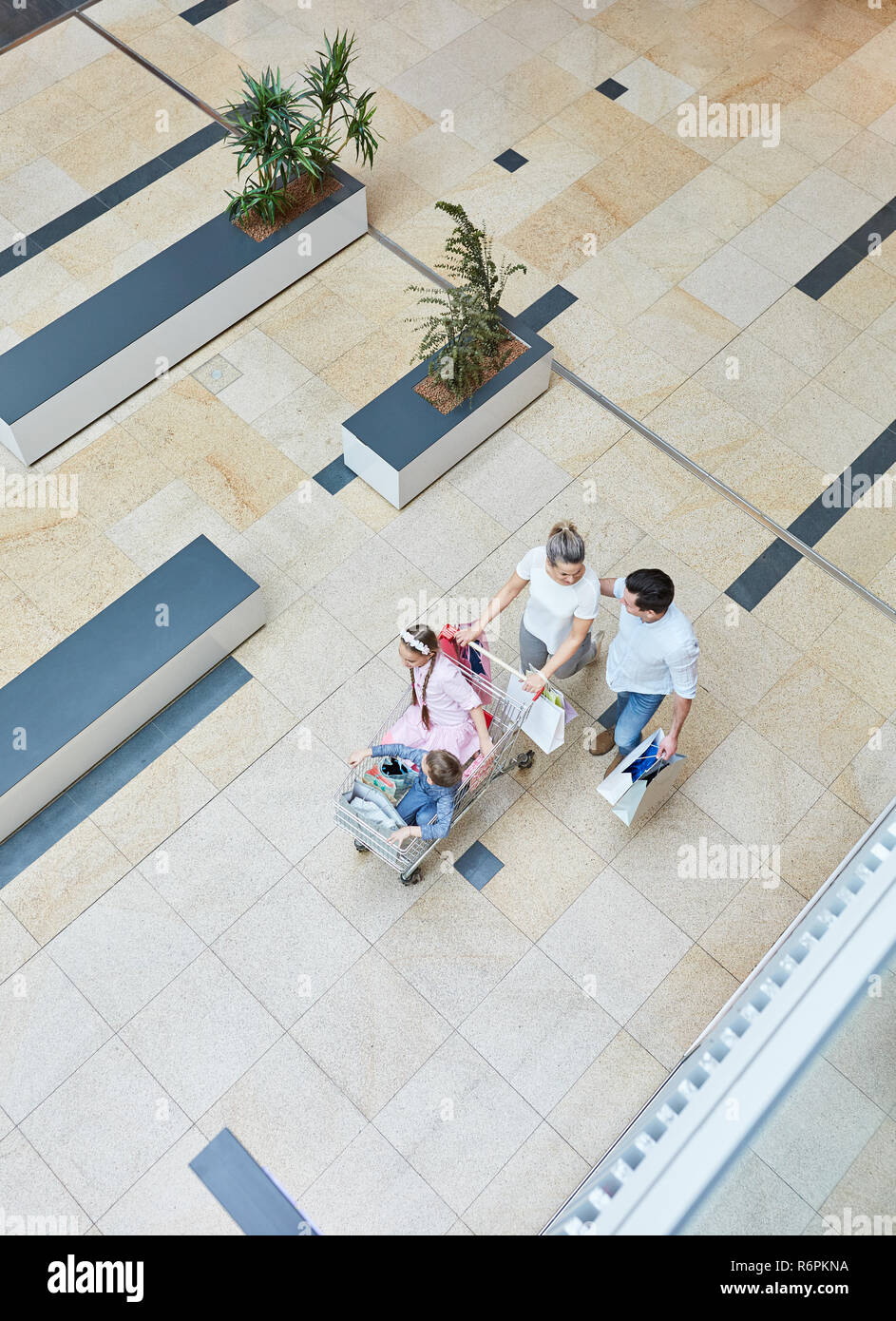 La famiglia e i miei due bambini nel carrello della spesa Il carrello al mall Foto Stock